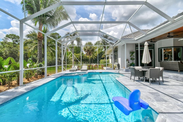 view of pool with a lanai, ceiling fan, an outdoor living space, and a patio