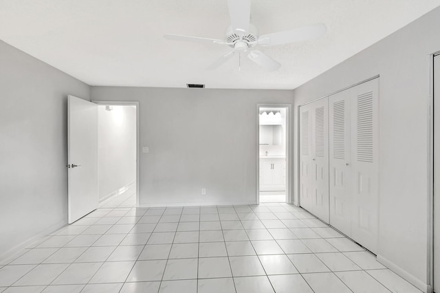 unfurnished bedroom featuring ceiling fan, light tile patterned flooring, and a closet