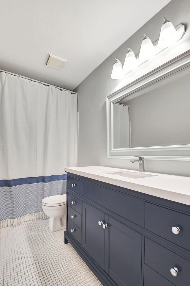 bathroom featuring tile patterned floors, vanity, and toilet