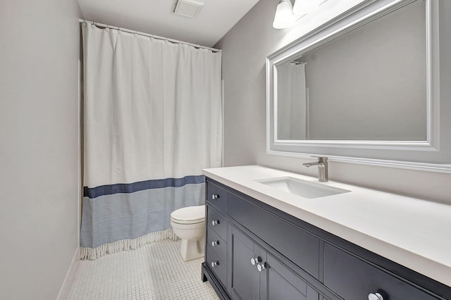 bathroom featuring tile patterned floors, vanity, and toilet