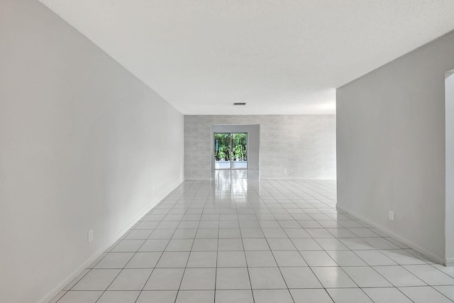 tiled spare room with a textured ceiling