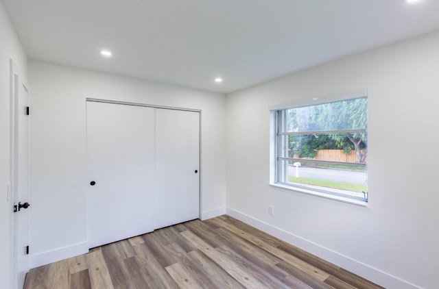 unfurnished bedroom with light wood-type flooring and a closet