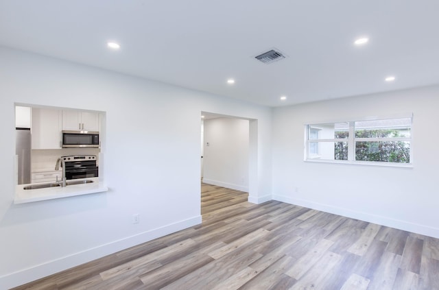 empty room with sink and light wood-type flooring