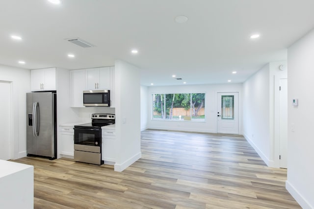 kitchen with white cabinetry, stainless steel appliances, and light hardwood / wood-style floors