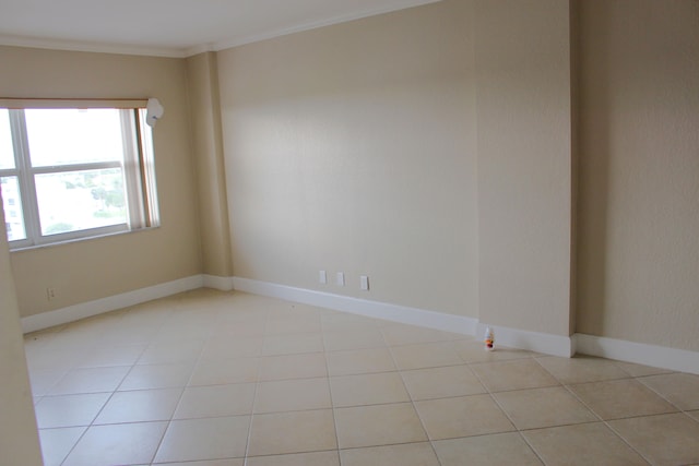 tiled empty room featuring crown molding