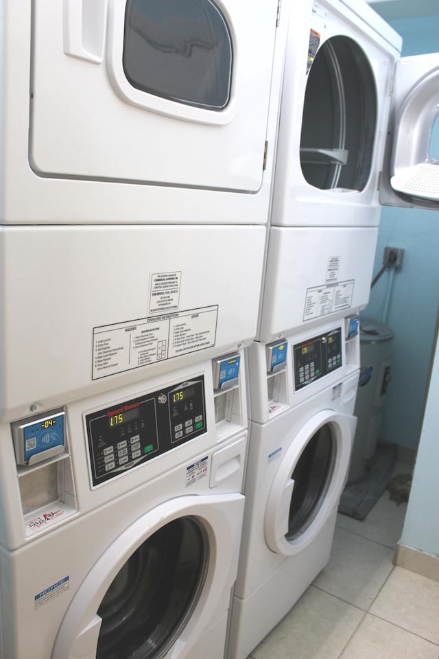 laundry area with independent washer and dryer, light tile patterned flooring, and stacked washing maching and dryer