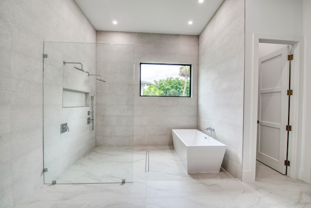 bathroom featuring shower with separate bathtub