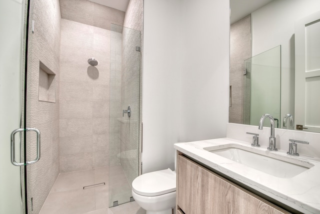 bathroom with a shower with shower door, toilet, and vanity