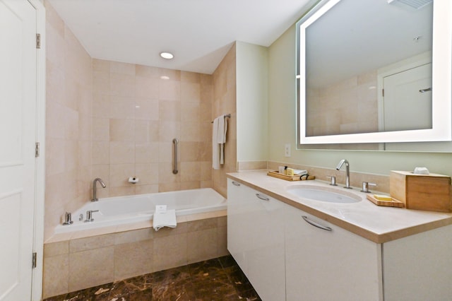 bathroom featuring vanity and tiled tub