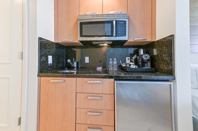 kitchen featuring decorative backsplash, sink, dark stone counters, and appliances with stainless steel finishes