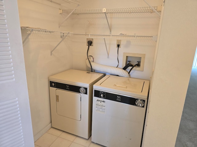 laundry room with light tile patterned floors and washer and clothes dryer