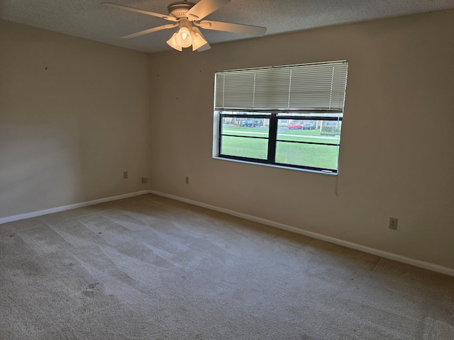 carpeted spare room featuring a textured ceiling and ceiling fan