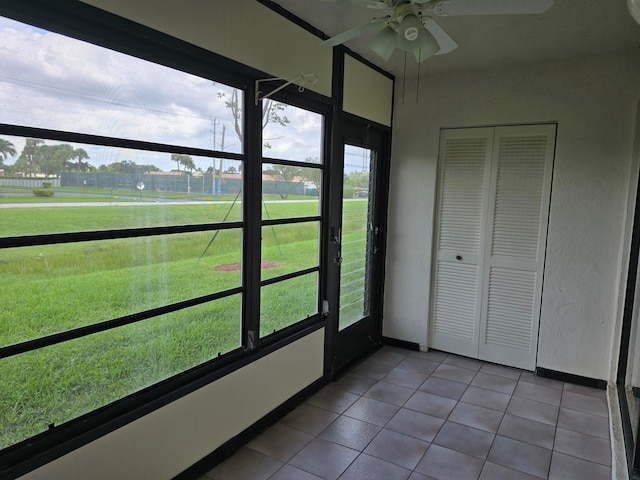 unfurnished sunroom with ceiling fan