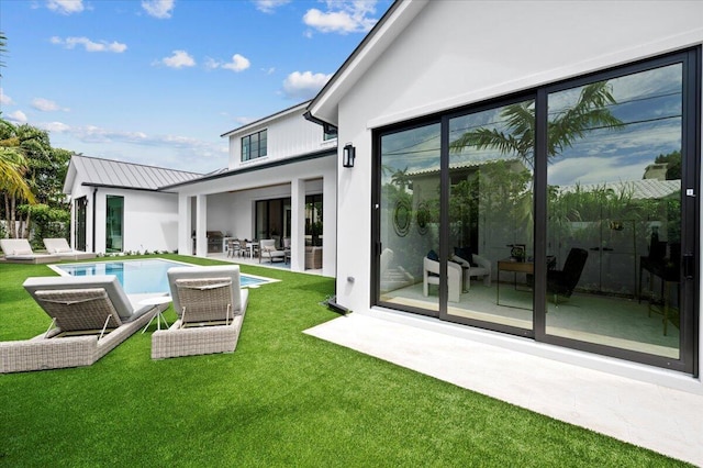 224 Edmor Rd, West Palm Beach, FL 33405 - back of house with an outdoor pool, a lawn, a patio, and stucco siding