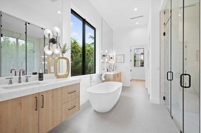 224 Edmor Rd, West Palm Beach, FL 33405 - bathroom featuring plenty of natural light, a stall shower, two vanities, a soaking tub, and recessed lighting