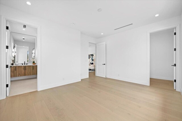224 Edmor Rd, West Palm Beach, FL 33405 - empty room featuring light wood-style flooring, recessed lighting, baseboards, and a sink