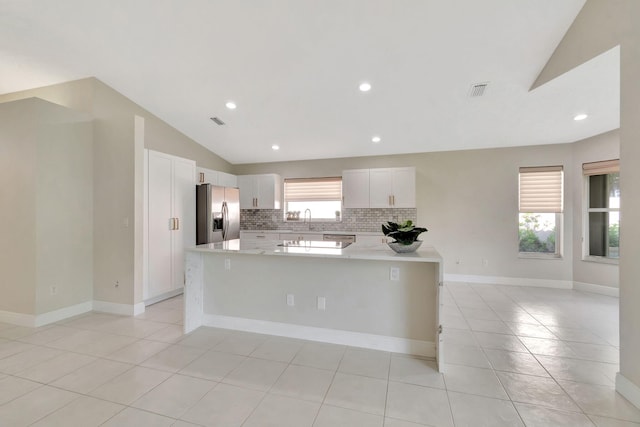 kitchen featuring lofted ceiling, white cabinetry, a healthy amount of sunlight, and stainless steel appliances