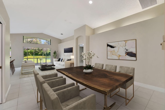 dining space featuring light tile patterned floors and vaulted ceiling