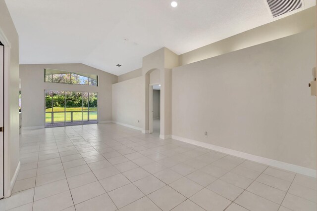 spare room with lofted ceiling and light tile patterned floors