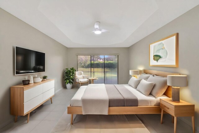 bedroom featuring ceiling fan, a tray ceiling, baseboards, and light tile patterned flooring