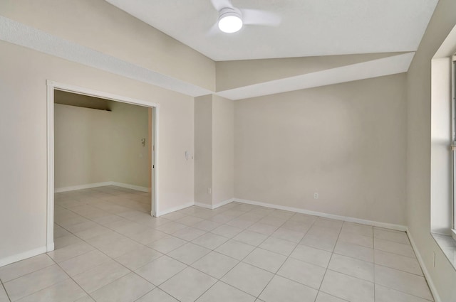 tiled empty room featuring lofted ceiling and ceiling fan