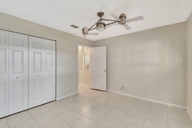 unfurnished bedroom featuring light tile patterned floors, a closet, and ceiling fan