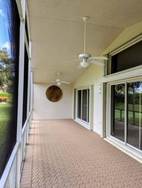 unfurnished sunroom featuring lofted ceiling and a ceiling fan