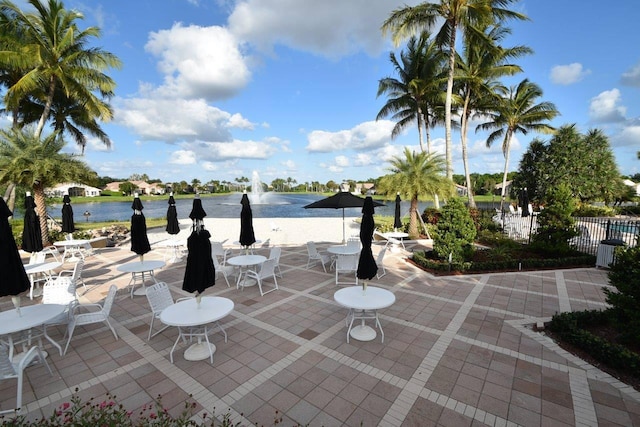 view of patio featuring a water view and fence