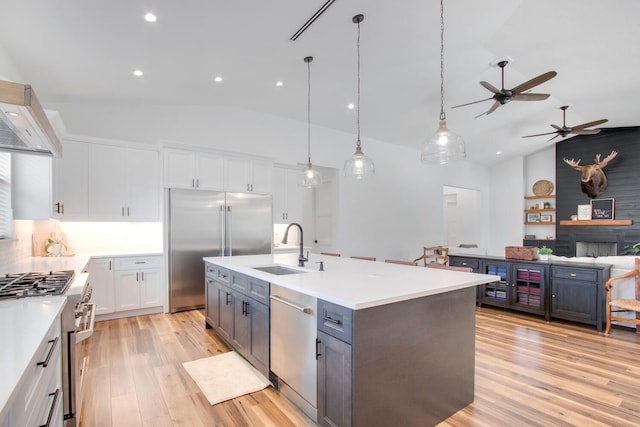 kitchen with a fireplace, white cabinetry, sink, ceiling fan, and high quality appliances