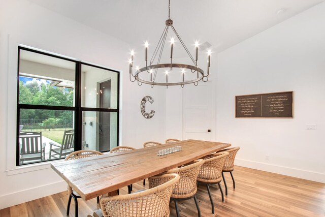 dining room with vaulted ceiling, a chandelier, and light hardwood / wood-style flooring