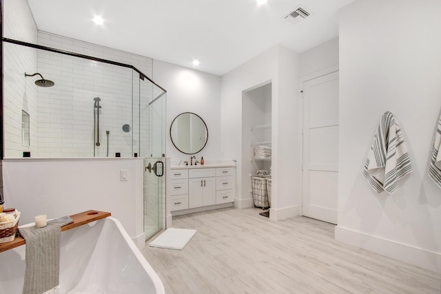 bathroom featuring hardwood / wood-style floors, shower with separate bathtub, and vanity