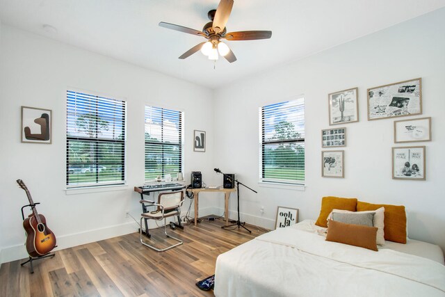 bedroom featuring multiple windows, hardwood / wood-style floors, and ceiling fan