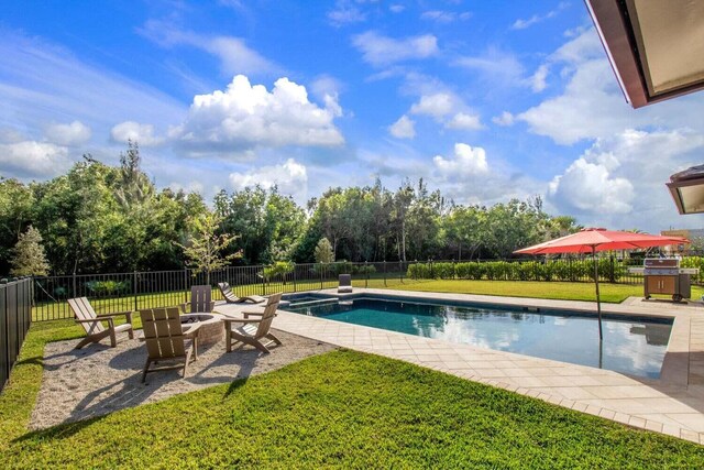 view of swimming pool featuring a yard, a patio, and an outdoor fire pit