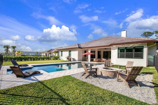 view of swimming pool with a yard, a patio area, and an outdoor fire pit