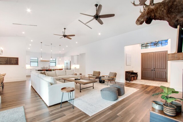 living room featuring high vaulted ceiling, light hardwood / wood-style flooring, and ceiling fan