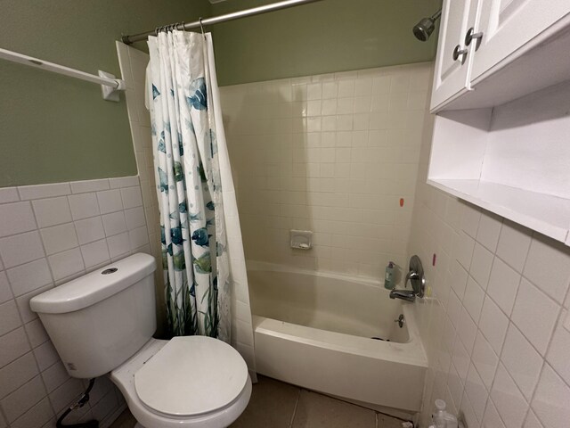 bathroom with tile patterned flooring, toilet, tile walls, and shower / tub combo with curtain