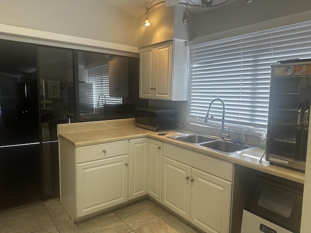 kitchen featuring light tile patterned flooring, white cabinetry, and sink