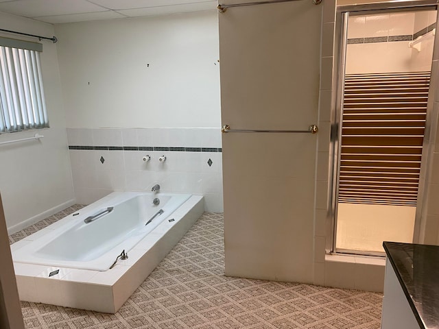 bathroom with separate shower and tub and tile walls