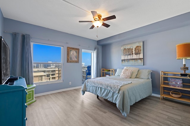 bedroom featuring hardwood / wood-style flooring, ceiling fan, and a textured ceiling