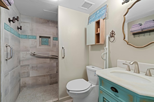 bathroom featuring toilet, vanity, and tiled shower