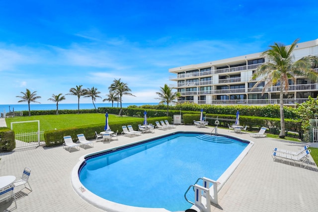 view of swimming pool with a patio area and a water view