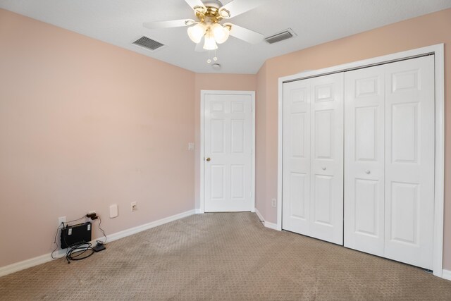 unfurnished bedroom featuring a closet, ceiling fan, and light colored carpet