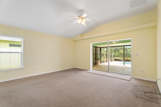 spare room featuring lofted ceiling, ceiling fan, a wealth of natural light, and light colored carpet