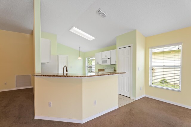 kitchen with white appliances, pendant lighting, light carpet, white cabinetry, and lofted ceiling