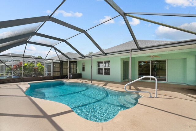 view of pool featuring ceiling fan, a patio area, and glass enclosure