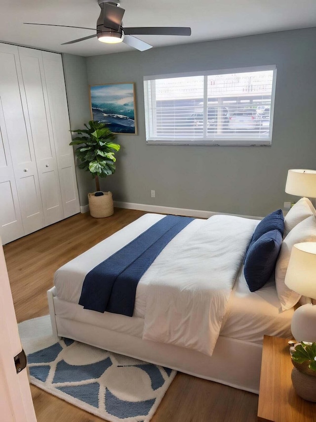 bedroom with ceiling fan, a closet, and hardwood / wood-style flooring