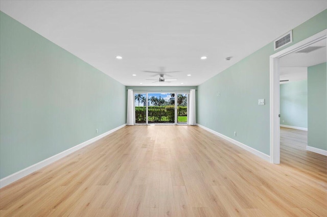 empty room with ceiling fan and light hardwood / wood-style floors