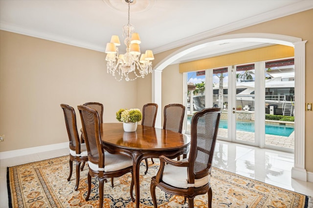 dining space featuring a chandelier, crown molding, and french doors