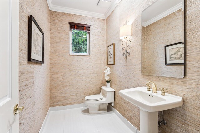 bathroom with tile patterned flooring, toilet, and crown molding