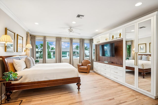 bedroom featuring light hardwood / wood-style flooring, ceiling fan, and crown molding